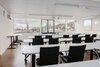 Moderne Lernumgebung in der Benedict Schule/BBS Business-School St. Gallen mit Blick auf historische Gebäude im Hintergrund.